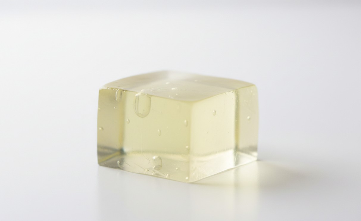 Translucent pale yellow GelMA hydrogel cube in laboratory setting