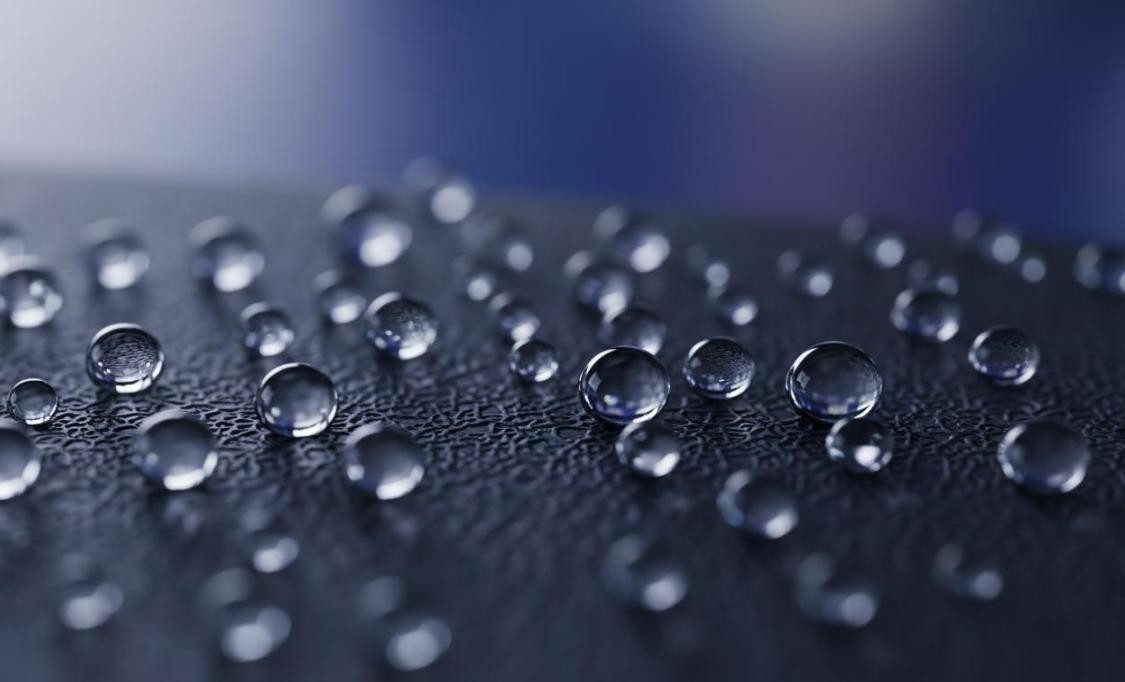 Superhydrophobic nanocoated surface with perfectly spherical water droplets showing contact angles above 150 degrees demonstrating extreme water repellency
